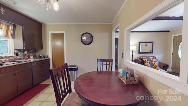 tiled dining room with crown molding and sink