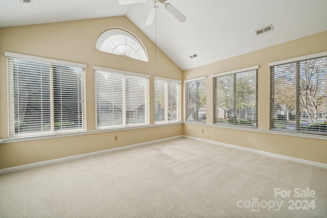 unfurnished sunroom featuring a healthy amount of sunlight, ceiling fan, and vaulted ceiling