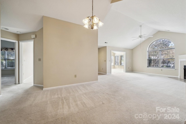 unfurnished living room with ceiling fan with notable chandelier, light colored carpet, a fireplace, and high vaulted ceiling