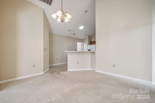 unfurnished living room featuring high vaulted ceiling, light carpet, and a notable chandelier