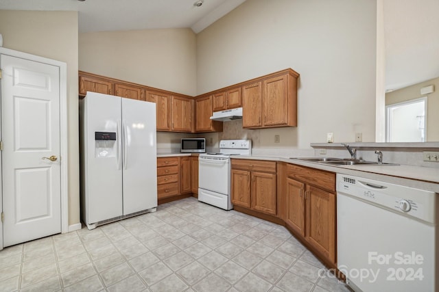 kitchen featuring white appliances, sink, and high vaulted ceiling