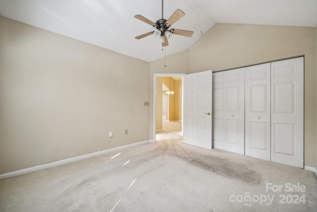 unfurnished bedroom with ceiling fan with notable chandelier, light colored carpet, high vaulted ceiling, and a closet