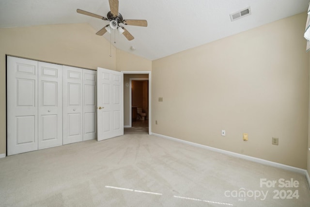 unfurnished bedroom with ceiling fan, light carpet, a closet, and vaulted ceiling