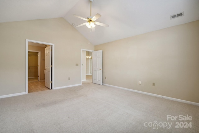 unfurnished bedroom featuring high vaulted ceiling, light colored carpet, ceiling fan, and ensuite bath