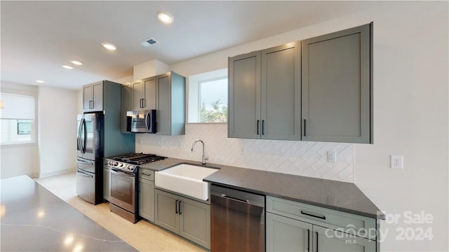 kitchen featuring gray cabinets, appliances with stainless steel finishes, sink, and tasteful backsplash