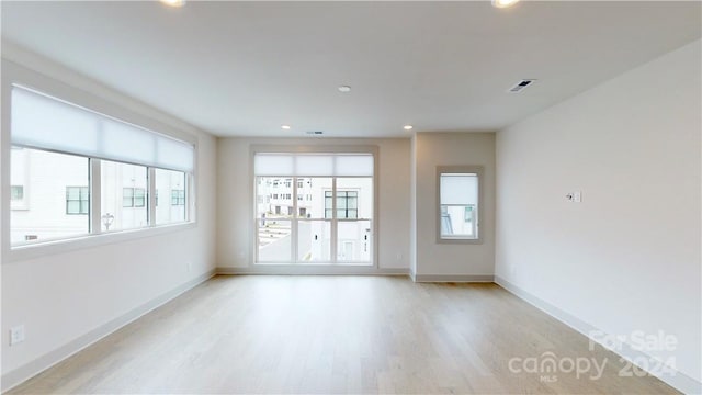 spare room with a wealth of natural light and light wood-type flooring