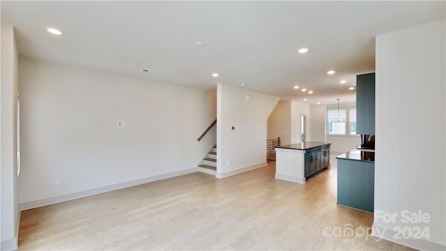 kitchen with pendant lighting, light wood-type flooring, and a kitchen island