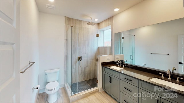 bathroom featuring walk in shower, wood-type flooring, vanity, and toilet