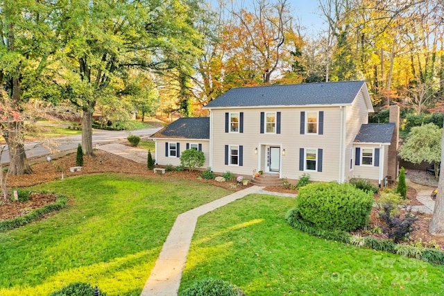 colonial inspired home with a front lawn