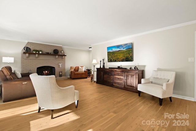 living room featuring crown molding, light hardwood / wood-style flooring, and a brick fireplace