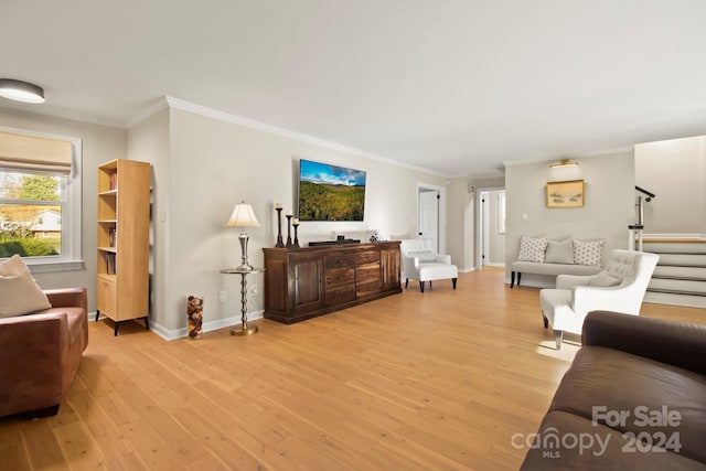 living room with light wood-type flooring and ornamental molding