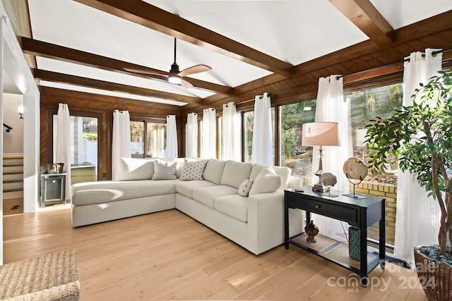 living room with vaulted ceiling with beams, ceiling fan, and light wood-type flooring