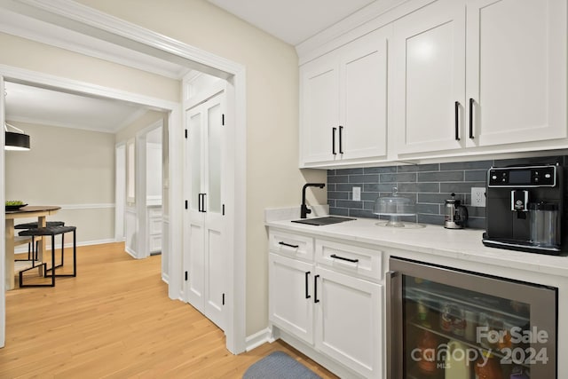 bar with white cabinets, decorative backsplash, light hardwood / wood-style flooring, and wine cooler