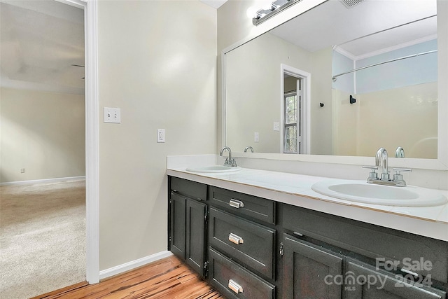 bathroom featuring hardwood / wood-style flooring, vanity, and ornamental molding