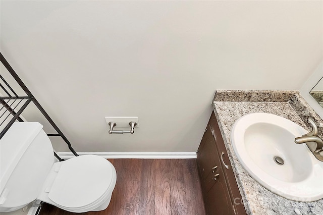 bathroom with hardwood / wood-style floors, vanity, and toilet