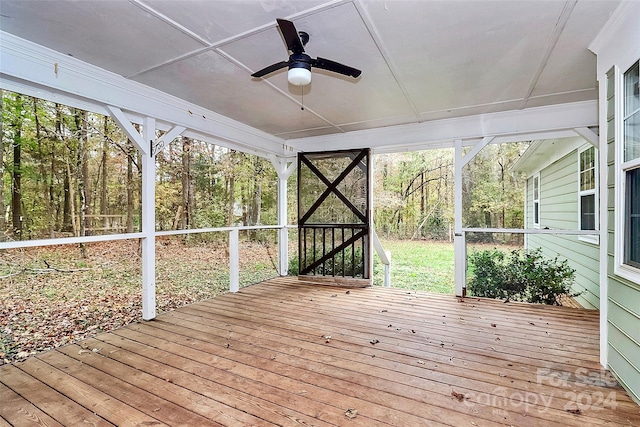 unfurnished sunroom with ceiling fan