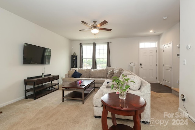 carpeted living room with ceiling fan