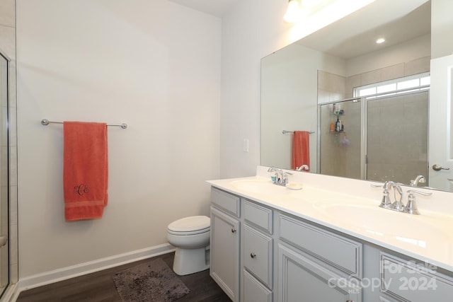 bathroom with hardwood / wood-style floors, vanity, toilet, and an enclosed shower