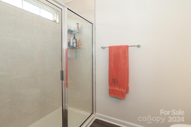 bathroom featuring hardwood / wood-style floors and a shower with door