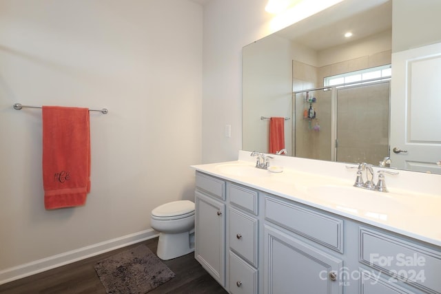 bathroom with hardwood / wood-style flooring, vanity, toilet, and walk in shower