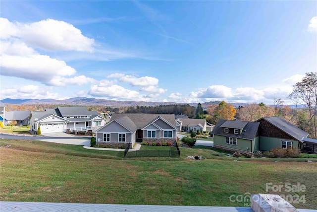 ranch-style house featuring a garage, a front lawn, and a mountain view