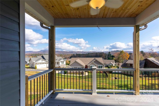 wooden terrace featuring a lawn, ceiling fan, and a mountain view