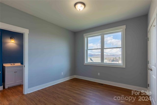 unfurnished bedroom featuring dark hardwood / wood-style floors and a closet