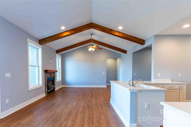 2637 Bowden Ln, Hendersonville, NC 28792 - kitchen with light wood finished floors, light countertops, a stone fireplace, a ceiling fan, and a sink