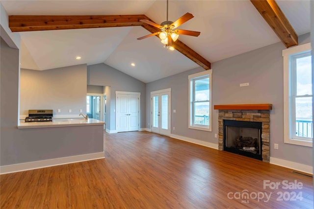2637 Bowden Ln, Hendersonville, NC 28792 - unfurnished living room featuring wood finished floors, a stone fireplace, ceiling fan, baseboards, and a sink
