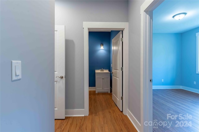 hall with light wood-type flooring and sink