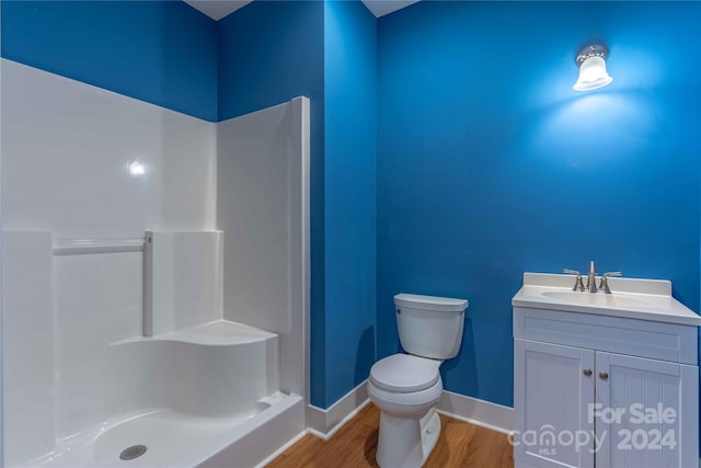 bathroom featuring a shower, vanity, toilet, and hardwood / wood-style floors