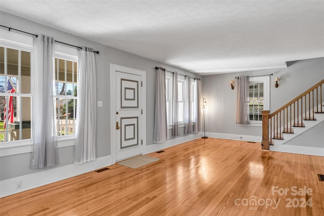 interior space with hardwood / wood-style floors, a wealth of natural light, and a textured ceiling