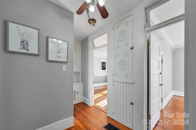 hallway featuring hardwood / wood-style flooring and crown molding