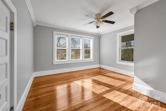 spare room with wood-type flooring, a healthy amount of sunlight, and crown molding