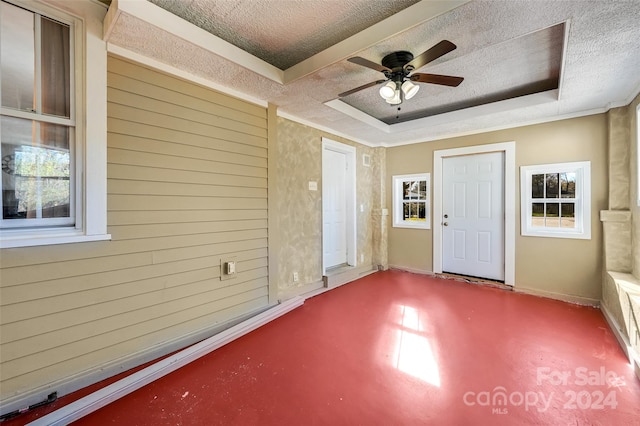 interior space featuring ceiling fan, a textured ceiling, and a tray ceiling