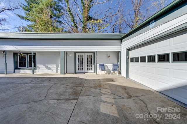 property entrance featuring a garage and french doors