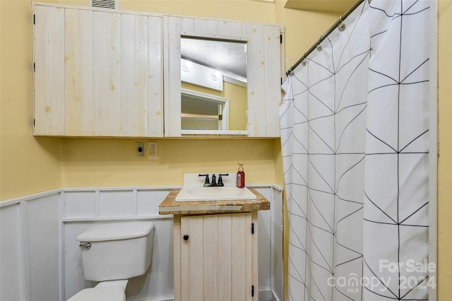 bathroom featuring curtained shower, vanity, and toilet