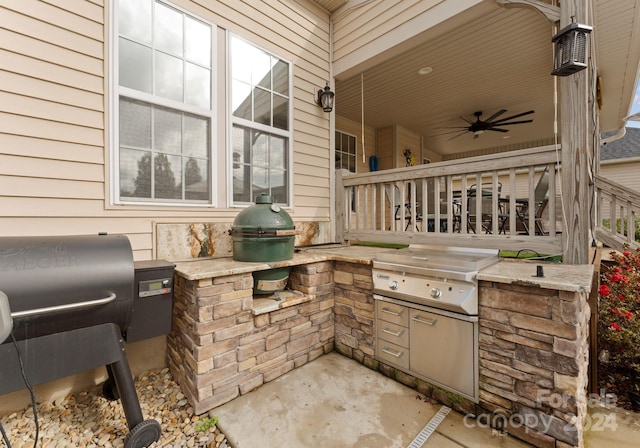 view of patio with area for grilling, ceiling fan, and a grill