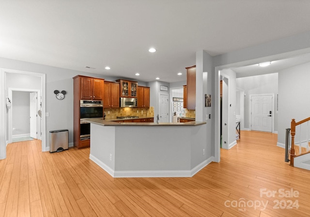 kitchen with kitchen peninsula, light hardwood / wood-style floors, and stainless steel appliances