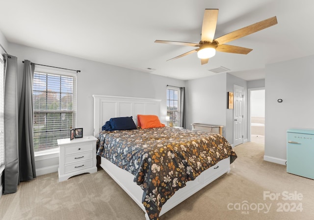 carpeted bedroom featuring connected bathroom, ceiling fan, and white fridge