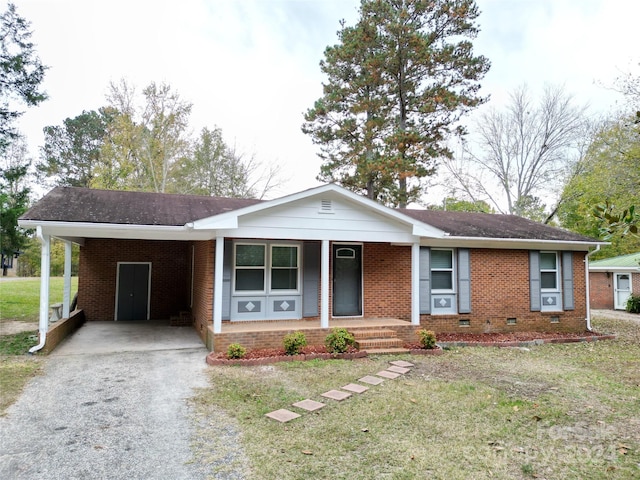 single story home featuring a front yard, a carport, and a porch