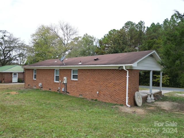 view of side of home with a lawn and a patio area