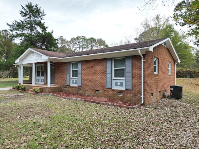 ranch-style home featuring a front lawn, cooling unit, and covered porch