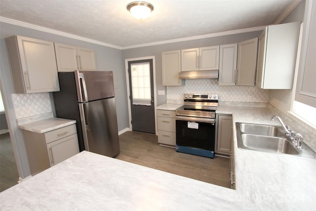 kitchen featuring stainless steel appliances, sink, light wood-type flooring, and backsplash