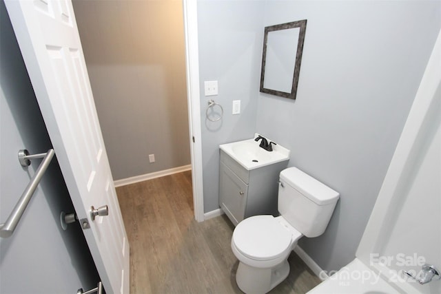 bathroom with hardwood / wood-style floors, vanity, and toilet