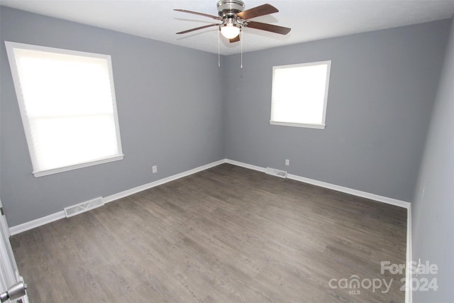 empty room with dark wood-type flooring and ceiling fan