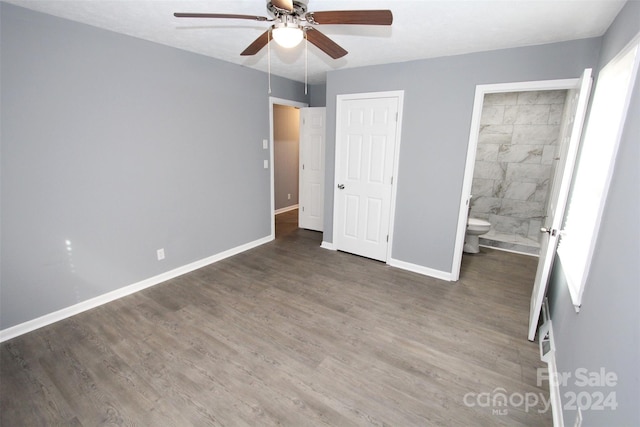 unfurnished bedroom featuring ensuite bath, ceiling fan, and dark hardwood / wood-style flooring