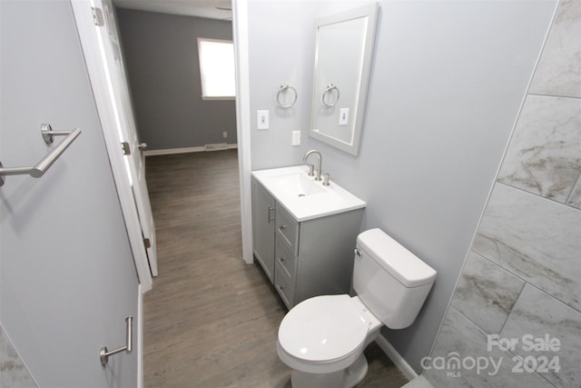 bathroom with hardwood / wood-style floors, vanity, and toilet