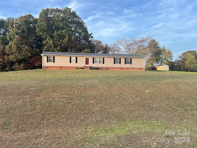 manufactured / mobile home with a storage unit and a front yard