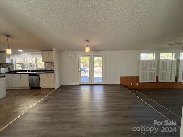 unfurnished living room featuring sink, dark wood-type flooring, and a textured ceiling